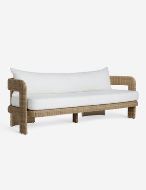 Angled view of the Hadler modern sculptural open frame wicker outdoor sofa.