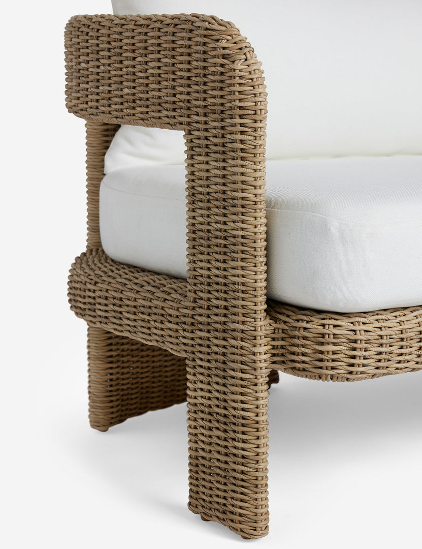 #color::natural | Close up of the arm of the Hadler modern sculptural open frame wicker outdoor sofa.