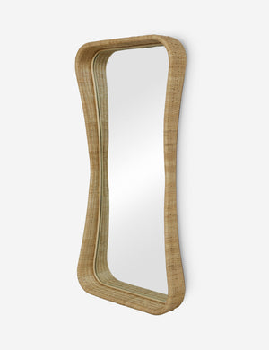 Angled view of the Howell wicker frame floor mirror.