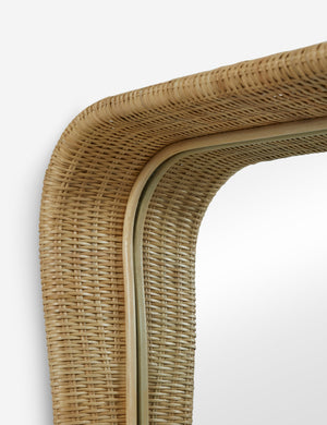 Close up of the top corner of the Howell wicker frame floor mirror.