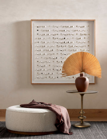 #color::brass | Caratto round matte brass finish metal side table styled next to a large round ottoman and modern wall artwork.