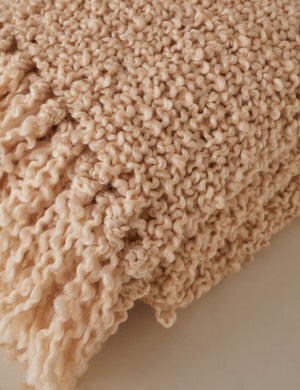 Close up of the fringe of the Jaffe chunky knit fringed outdoor throw blanket in natural.