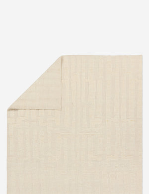 Folded corner showing the back of the Pacheco hand-knotted wool ivory area rug.