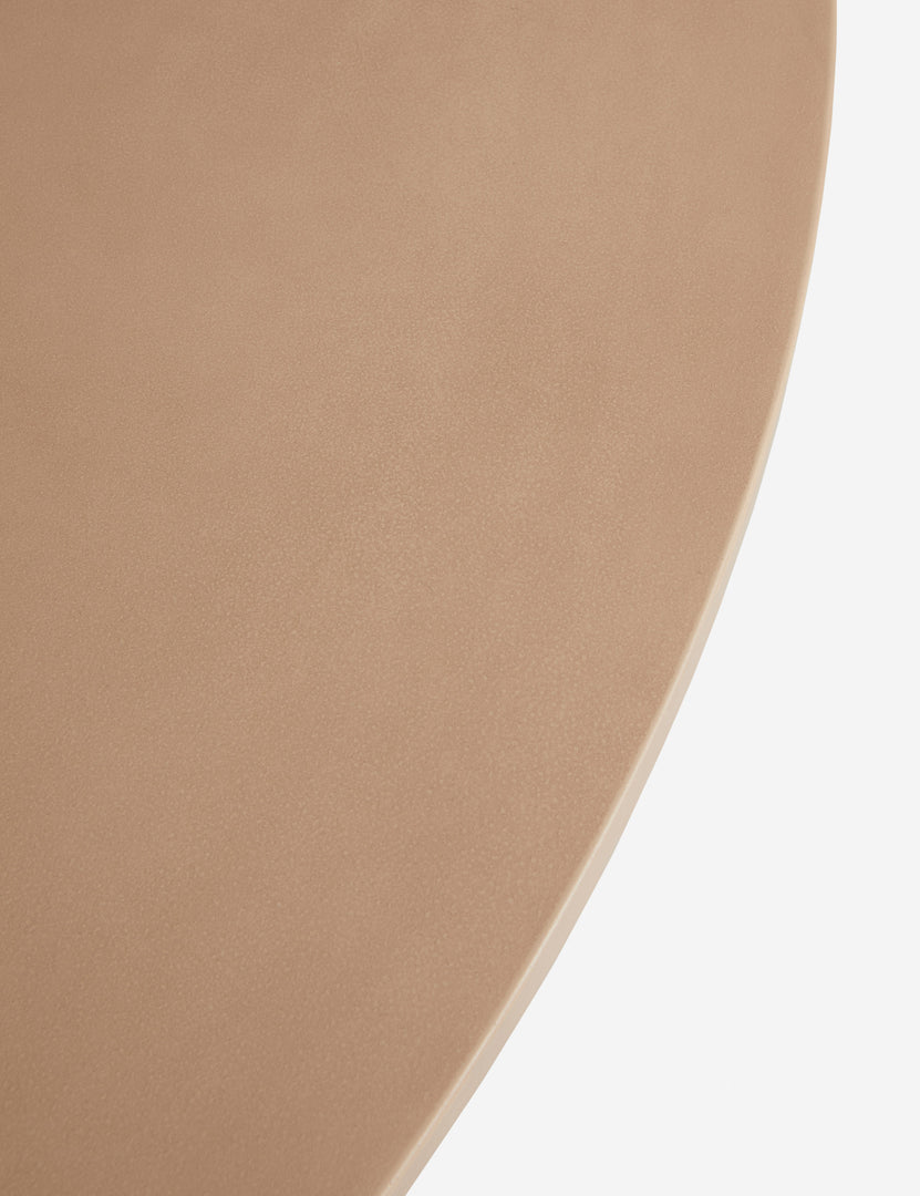 #color::terracotta | Close up of the Keating sculptural round fiberstone outdoor dining table.