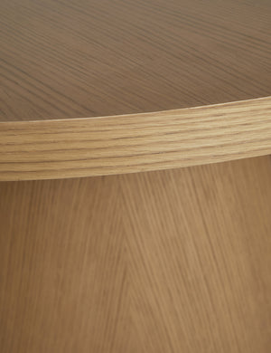 Close up of the Keating round geometric wood pedestal dining table.