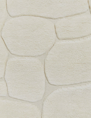 Close up view of the Kivi raised cobblestone pattern fringe wool area rug