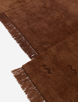 Close up view of the Koukero irregular shaped fringe wool area rug