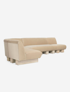 Angled view of the Lena left-facing beige velvet sectional sofa with upholstered beam legs.