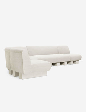 Angled view of the Lena left-facing natural linen sectional sofa with upholstered beam legs.