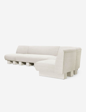 Angled view of the Lena right-facing natural linen sectional sofa with upholstered beam legs.
