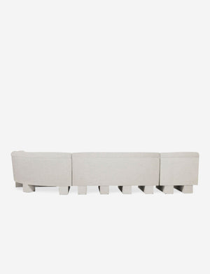 Rear view of the entire Lena right-facing natural linent sectional sofa with upholstered beam legs.