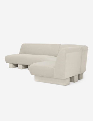 Angled view of the Lena right-facing white boucle sectional sofa with upholstered beam legs.