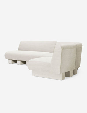 Angled view of the Lena right-facing natural linen sectional sofa with upholstered beam legs.