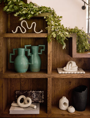 Decorative ceramic Ollis Knot by SIN Ceramics styled on a bookshelf