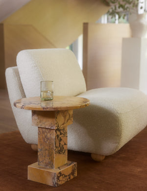 Potts round marble pedestal side table styled with an armless accent chair.