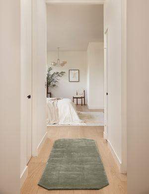 Hallway to a bedroom featuring the Damara solid viscose runner rug in sage.