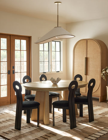 #color::brass #size::37-dia | Arroyo Mixed-Material Pendant Light by Elan Byrd hanging above a dining table.