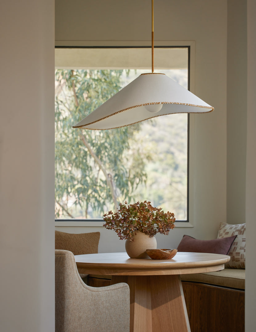 #color::brass #size::37-dia | Arroyo Mixed-Material Pendant Light by Elan Byrd hanging above a table in a dining nook.