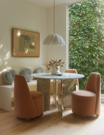 #color::white #size::20-dia | Nita pleated shade pendant light hung above a round marble dining table.