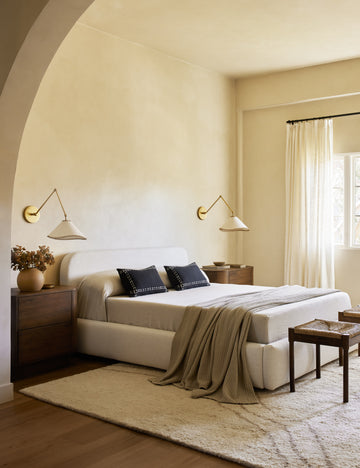 #color::brass | TwoArroyo Mixed-Material Adjustable Arm Sconces by Elan Byrd mounted above the nightstands in a bedroom.