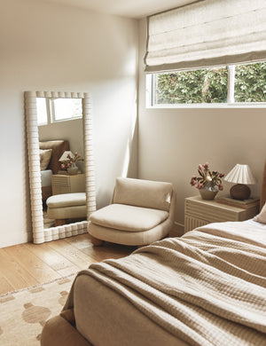 Lozano chunky low-profile armless accent chair styled in the corner of a bedroom.