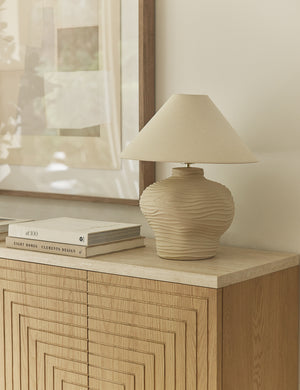 Wrinkle ceramic table lamp by Sarah Sherman Samuel styled on a sideboard cabinet.