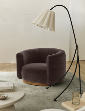 Lowry rounded silhouette velvet accent chair styled with a slim tripod floor lamp.