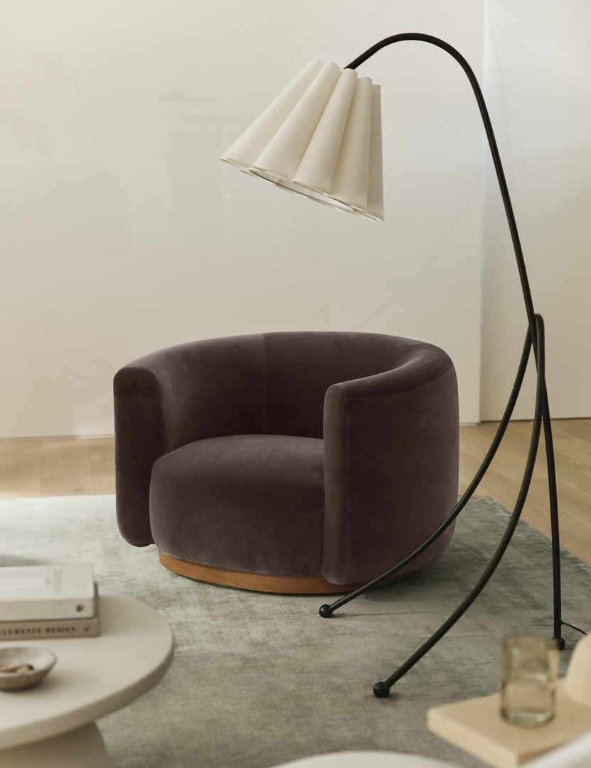 #color::mink-velvet | Lowry rounded silhouette velvet accent chair styled with a slim tripod floor lamp.
