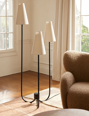 Familia slim 3-tapered shade floor lamp by Aimee Song styled next to an accent chair