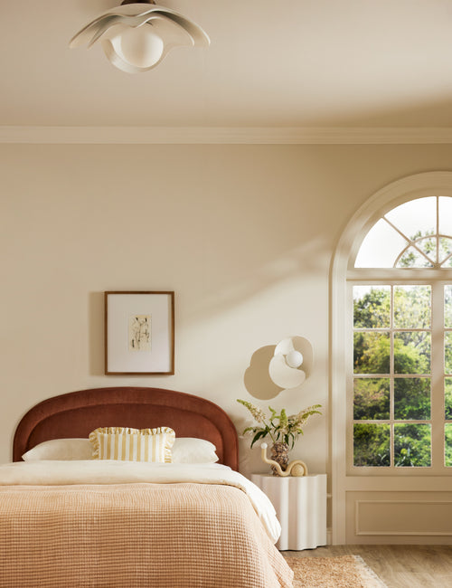 | Soft Petal matte white floral silhouette flush mount light hung above a bed in a bedroom