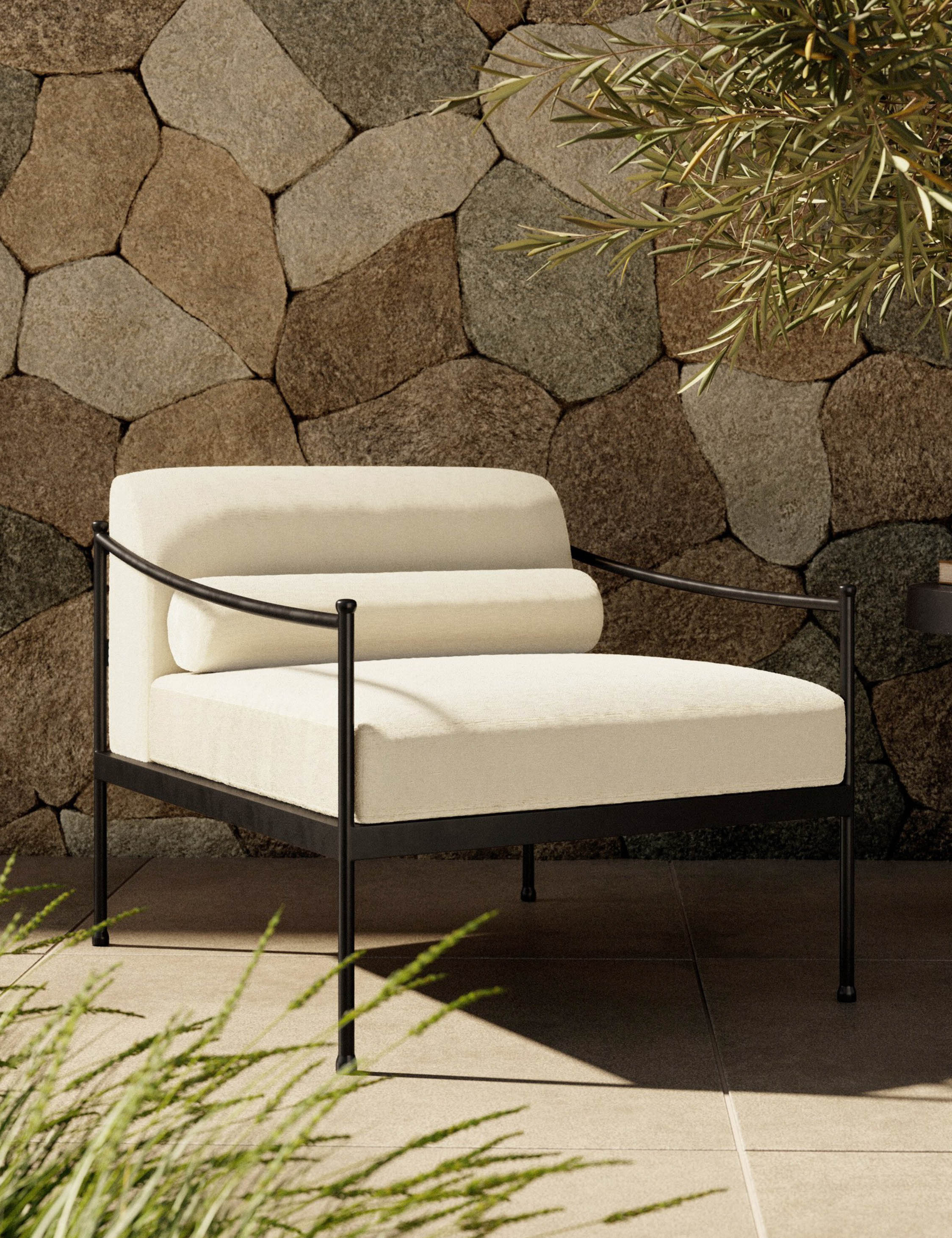 Modern outdoor lounge chair with cream/off-white cushions and slim black metal frame, curved arm supports, and a low-profile silhouette.