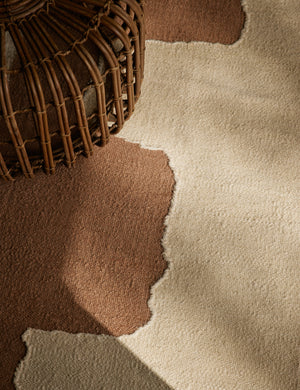 Close up of the Butte Flatweave Linen Rug by Elan Byrd under a rattan coffee table.