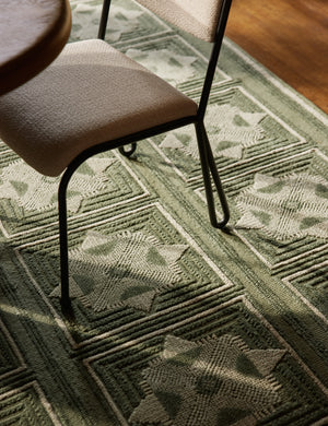 Close up of the Carlisle Geometric Motif Hand-Knotted Wool Rug by Aimee Song under a dining chair.