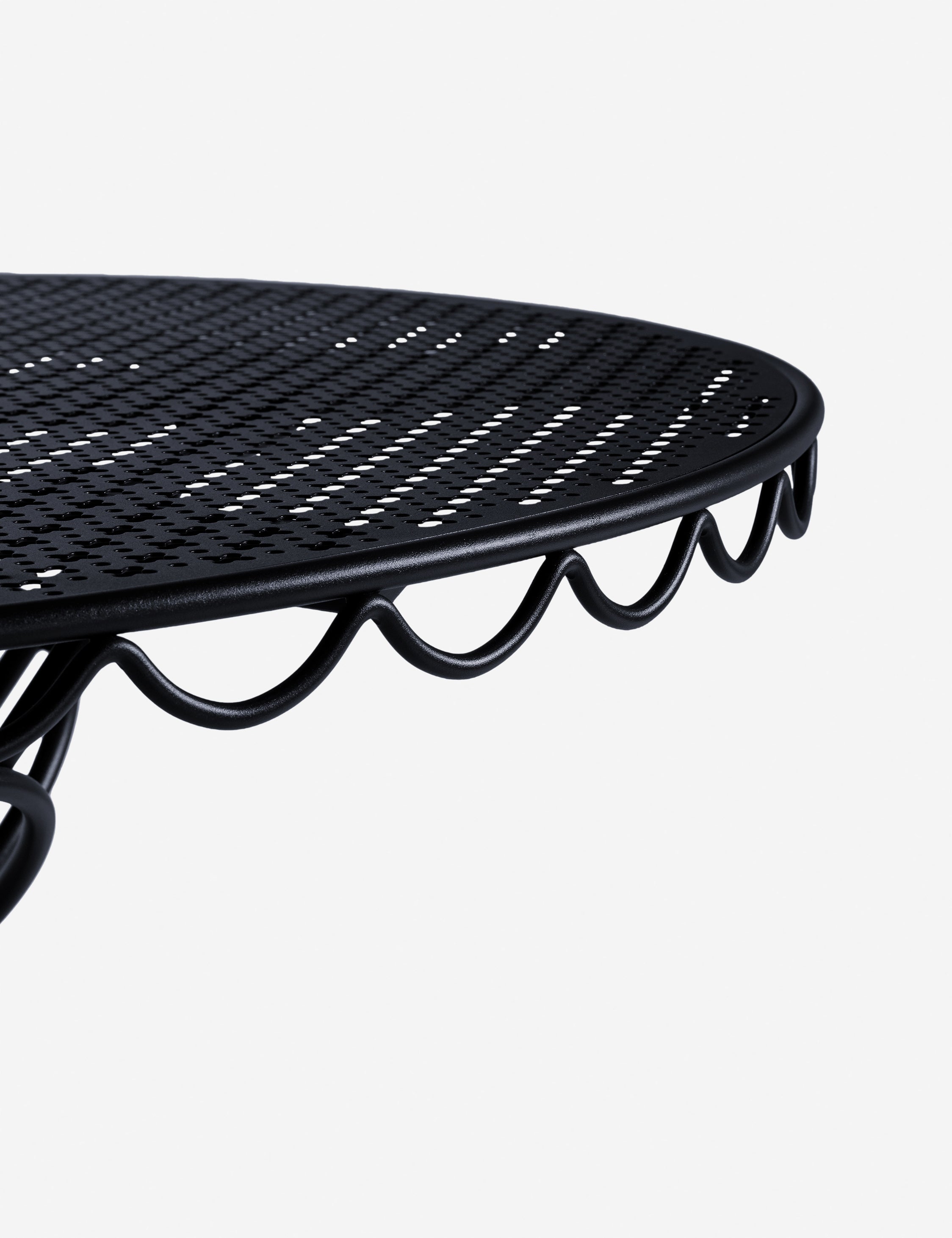 Close-up of the black mesh pattern on the tabletop of a bistro table.