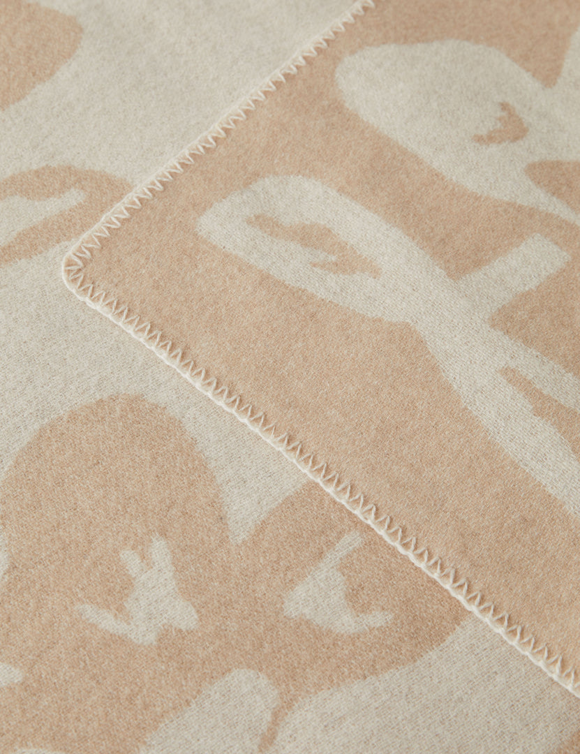#color::ivory-and-beige | Close up view of the Apila floral pattern wool throw blanket