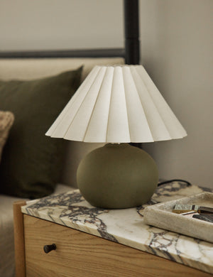Luis round ceramic mini table lamp styled on a marble top nighstand.