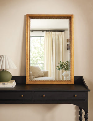 Corinne textural gold epoxy resin frame wall mirror styled on a black console table.