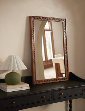Dane carved wood framed mirror styled on top of the black Topia console table with a small green table lamp