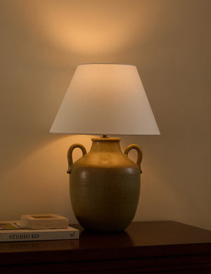 Delfina lug handle glazed ceramic table lamp by Heidi Caillier with the light turned on