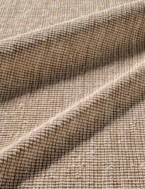 Close-up of the folded over corner of the Harriette scandinavian-inspired rug made of 100% jute