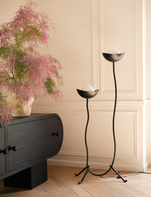 Kukka modern two light wavy base floor lamp in bronze next to a black console table