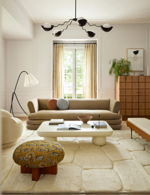 Kivi raised cobblestone pattern fringe wool area rug styled in a living room
