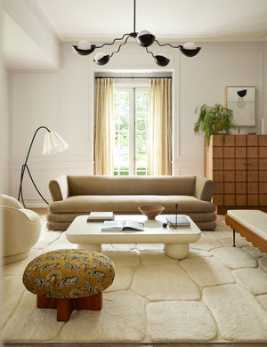 Kukka large modern wavy arm chandelier in bronze in a living room hanging over the coffee table