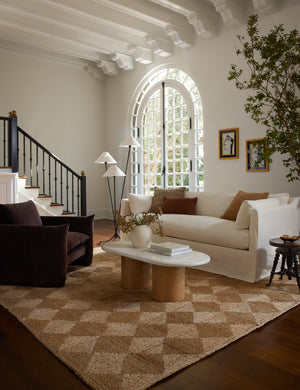 The Havenhurst Rug lays in a brown-toned living room under a brown velvet accent chair and ivory linen sofa