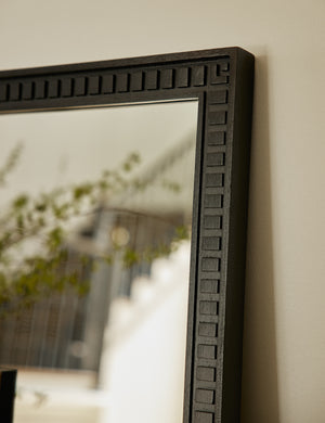 Close up top corner view of the Thelma black carved wood framed mirror