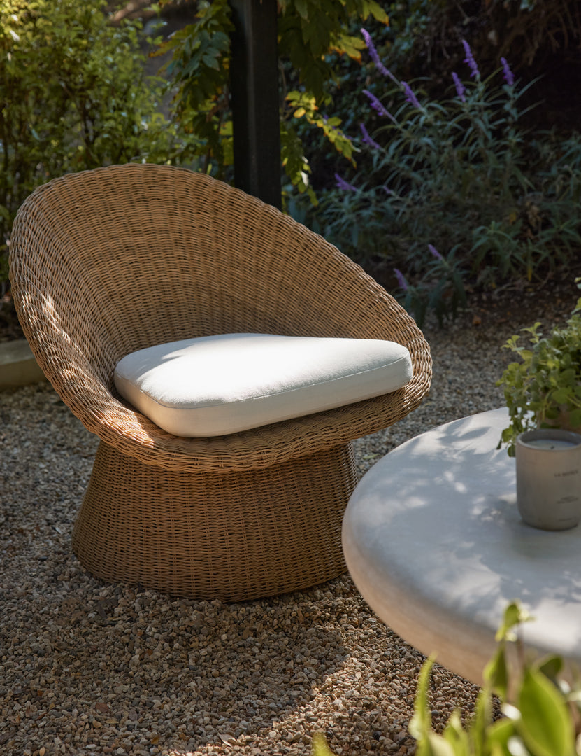 #color::natural | Ferran sculptural wicker outdoor accent chair styled with a white outdoor coffee table.
