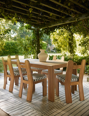 Shere handwoven striped outdoor rug by Sarah Sherman Samuel in Natural paired with a teak outdoor dining set.