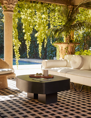 An outdoor lounge space featuring the Armas black monolithic round outdoor coffee table by Sarah Sherman Samuel.