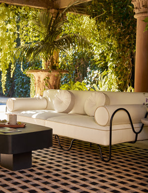 Covered outdoor lounge space featuring the Peggy sculptural iron frame and white cushion outdoor sofa.