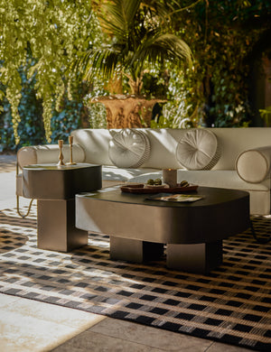 Armas black monolithic round outdoor side table by Sarah Sherman Samuel styled in an outdoor lounge space.